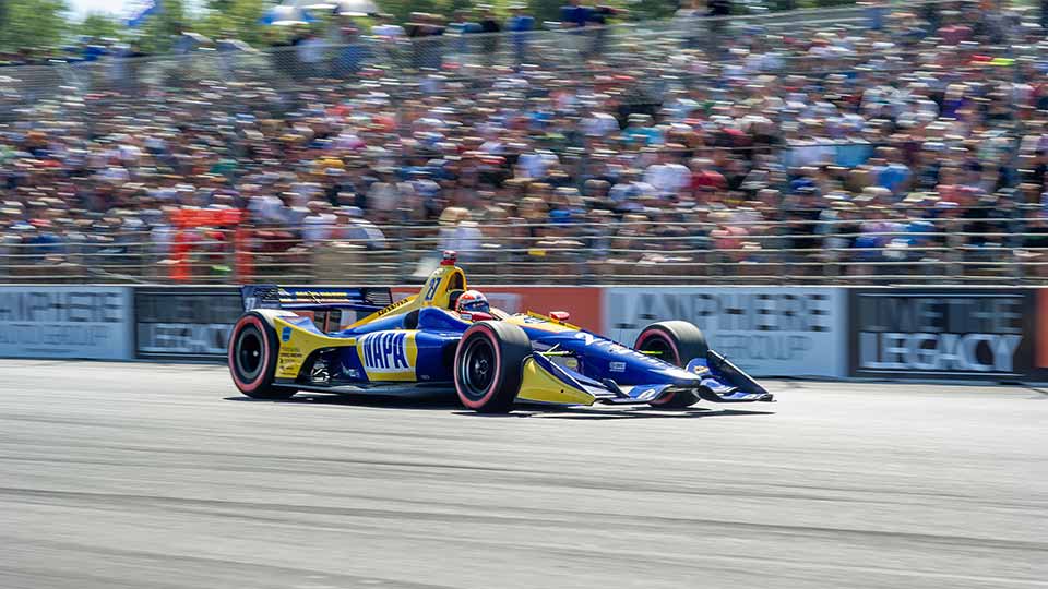 Alexander Rossi races by a full grandstand